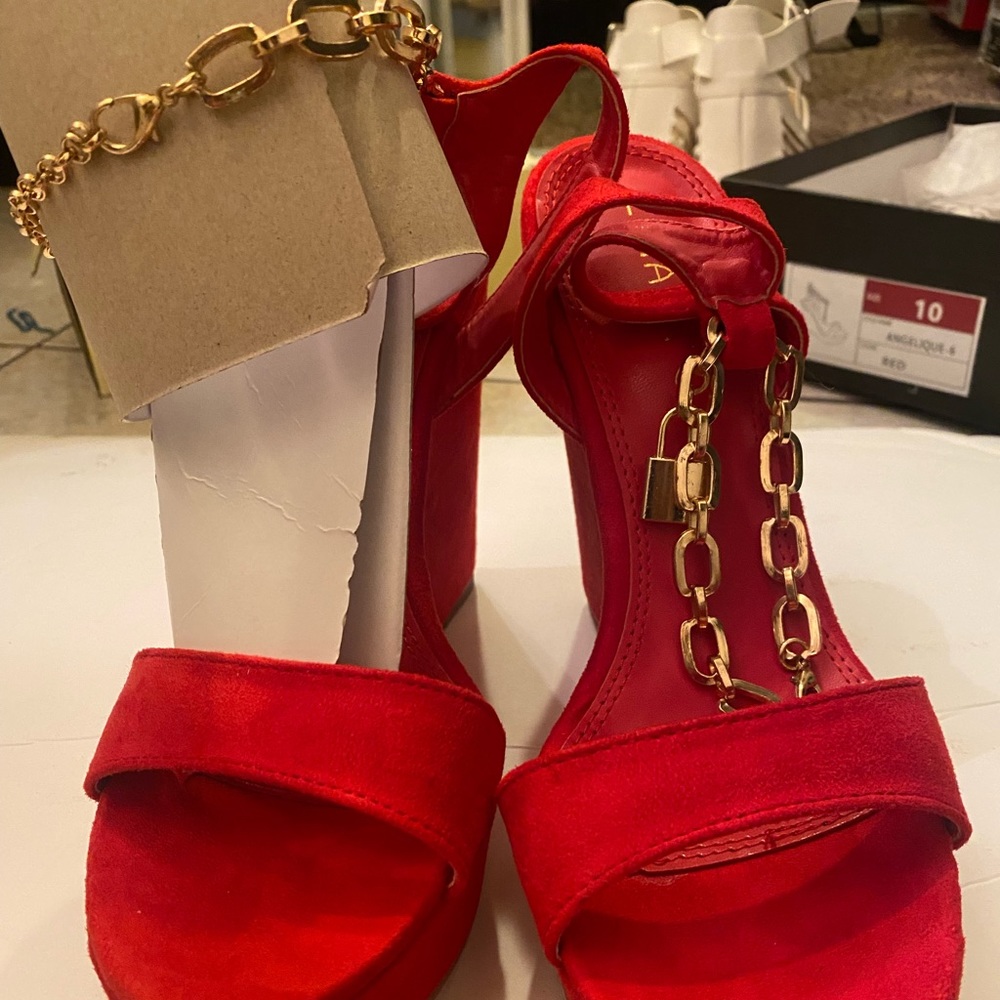 Red wedged shoes with bracelet clamped to ankle.